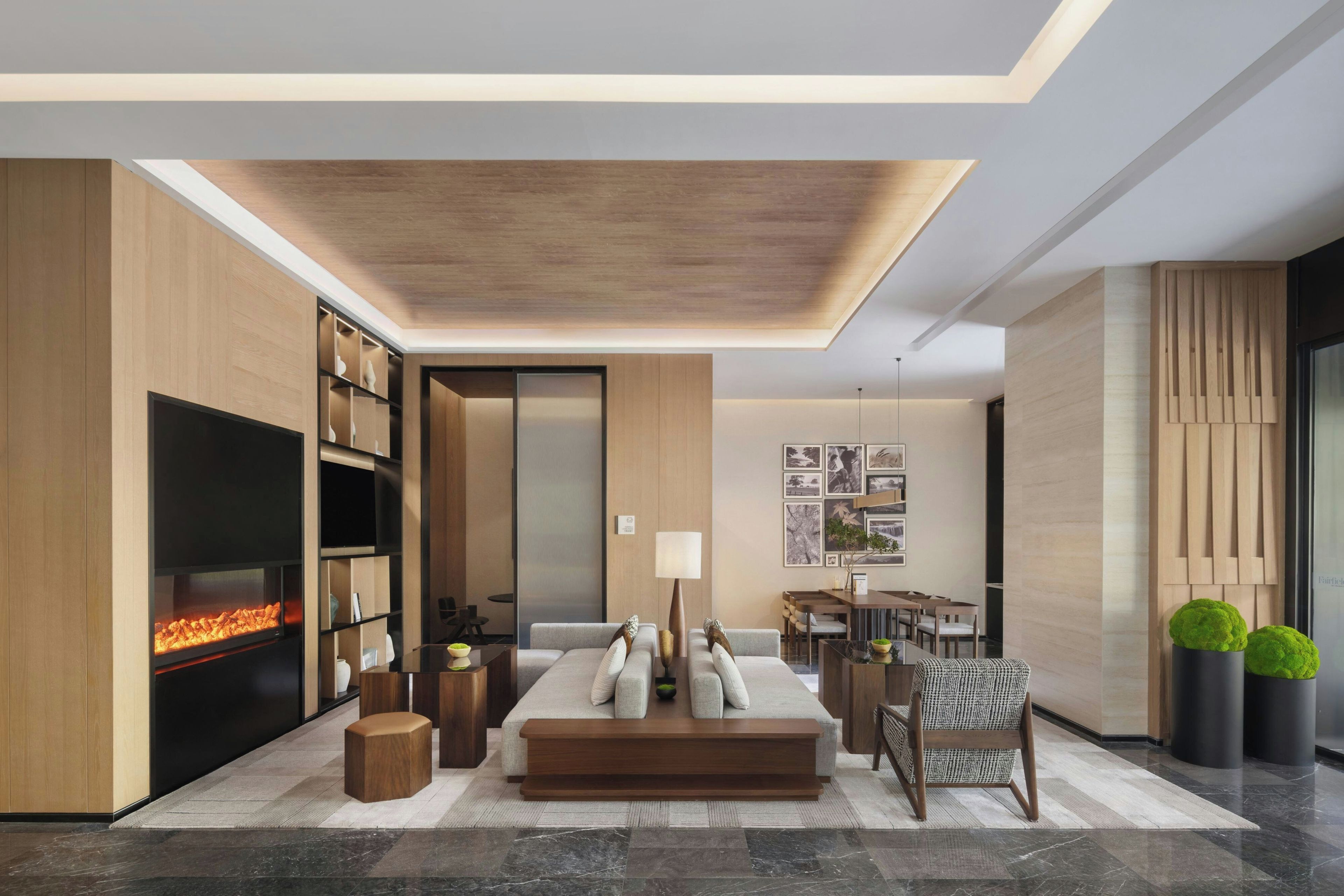 A modern living room with a fireplace, a sofa, a dining area, and a large TV.