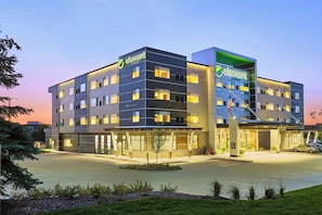 Um hotel com design moderno, vários andares e área de estacionamento.