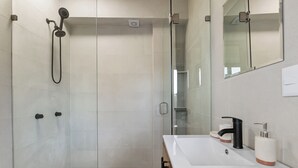 A modern bathroom with a shower, a sink, and a mirror. - Sol & Sal Studio Steps to Beach & Malecon (Puerto Vallarta)
