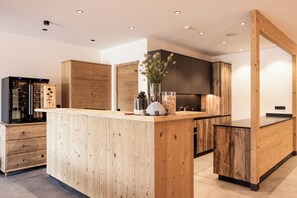 Una cucina moderna con mobili in legno, un'isola centrale ed elettrodomestici integrati.