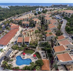 A resort with multiple buildings, a swimming pool, and a view of the ocean. - Walk to Beach - Pool Access - Walk to Restaurants - Laguna Vista (San José del Cabo)