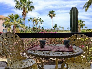 A round metal table with two chairs, a red tablecloth, and a cactus in the background. - Walk to Beach - Pool Access - Walk to Restaurants - Laguna Vista (San José del Cabo)