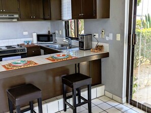 A kitchen with a central island, a microwave, a toaster, and a sink. - Walk to Beach - Pool Access - Walk to Restaurants - Laguna Vista (San José del Cabo)