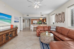 A spacious living room with a leather sofa, a coffee table, and a television. - *Majestic Sun A701*Updated*Heated Pools +Hot Tubs*Gym*Pickleball & Tennis* (Miramar Beach)