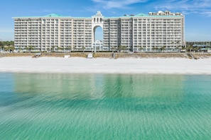 A large hotel with a central archway, located on a beach with clear turquoise water. - *Majestic Sun A701*Updated*Heated Pools +Hot Tubs*Gym*Pickleball & Tennis* (Miramar Beach)