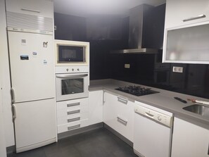 A compact kitchen with a built-in oven, microwave, and gas stove. - Single-Family Home in "Cenes De la Vega," Ideal for Families (Cenes de la Vega)