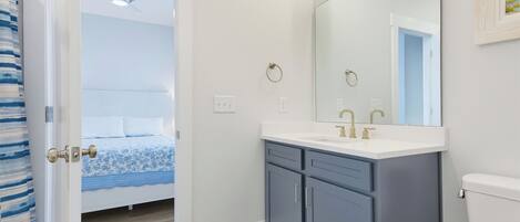 A bathroom with a white toilet, a double sink vanity, and a large mirror.
