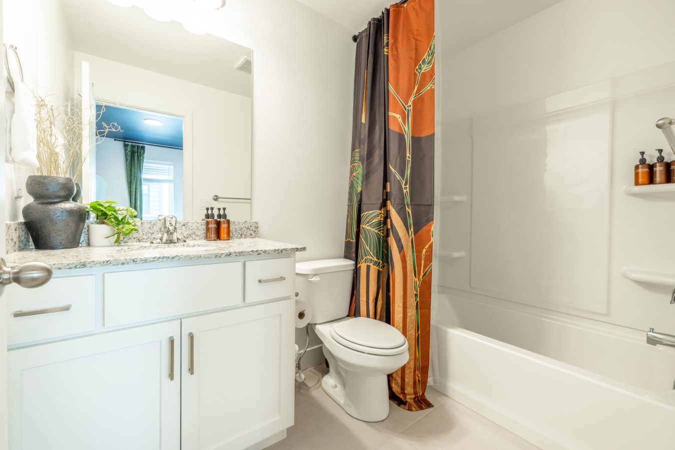A bathroom with a toilet, sink, and shower area.