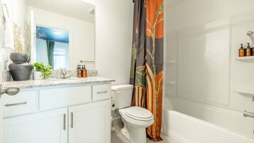 A bathroom with a toilet, sink, and shower area.