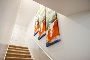 Un escalier avec une rampe et une porte blanche en haut.