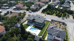A residential area with modern houses, a swimming pool, and a gas station. - SESU 2 - Çamyuva'da Denize Yakın 2+1 Apart (Kemer)