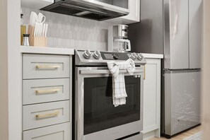 Een keuken met een ingebouwde oven, een koffiezetapparaat en een koelkast.
