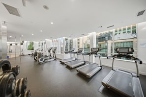 A modern gym with treadmills, elliptical machines, and free weights. - Luxe 1 BR + Den | Walk to CN Tower | Free Parking (Toronto)