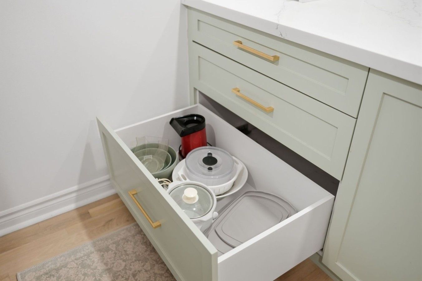 A kitchen drawer with various kitchen appliances and containers.