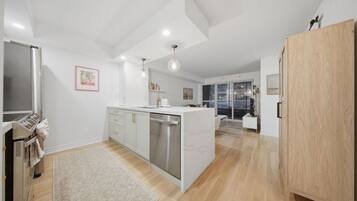 A modern kitchen with a central island, stainless steel appliances, and a wooden cabinet.