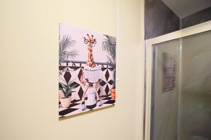 A wall with a giraffe illustration reading a newspaper.