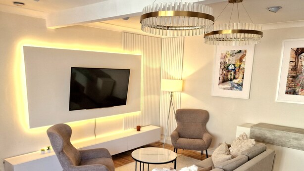 A modern living room with a flat-screen TV, two armchairs, a sofa, a coffee table, and a floor lamp. - Independent, Modern Annexe in Orpington (Orpington)