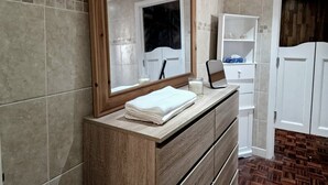 A bathroom with a wooden vanity, a mirror, and a white cabinet. - Independent, Modern Annexe in Orpington (Orpington)