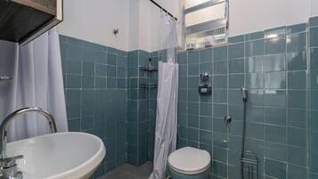Une salle de bain équipée d’un lavabo, de toilettes, d’une douche et d’une fenêtre donnant sur un beau paysage.