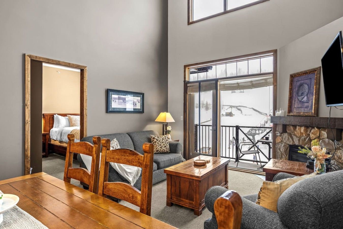 A cozy living room with a fireplace, a sofa, a wooden coffee table, and a dining table.