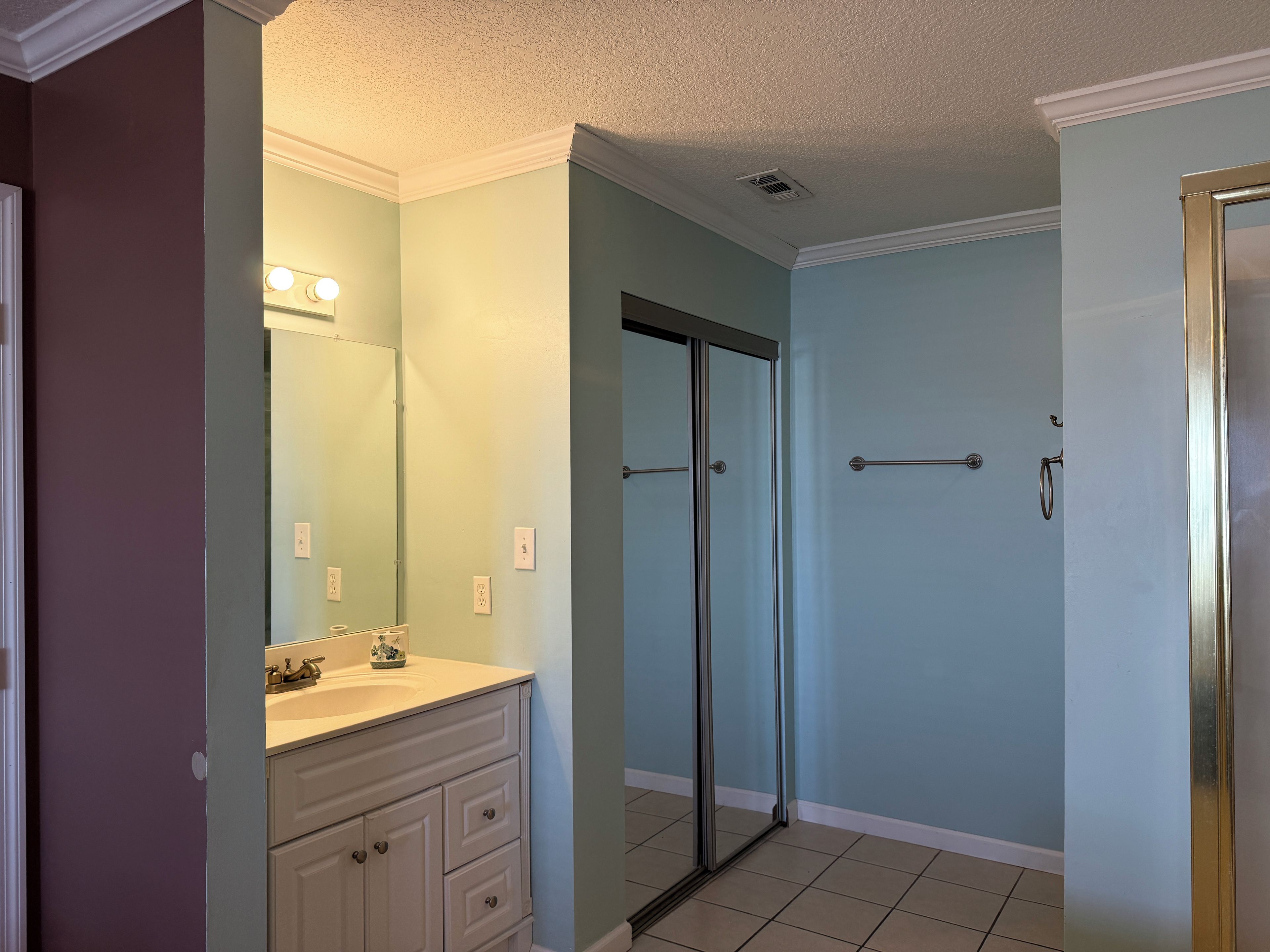 A bathroom with a vanity, mirror, toilet, and shower.