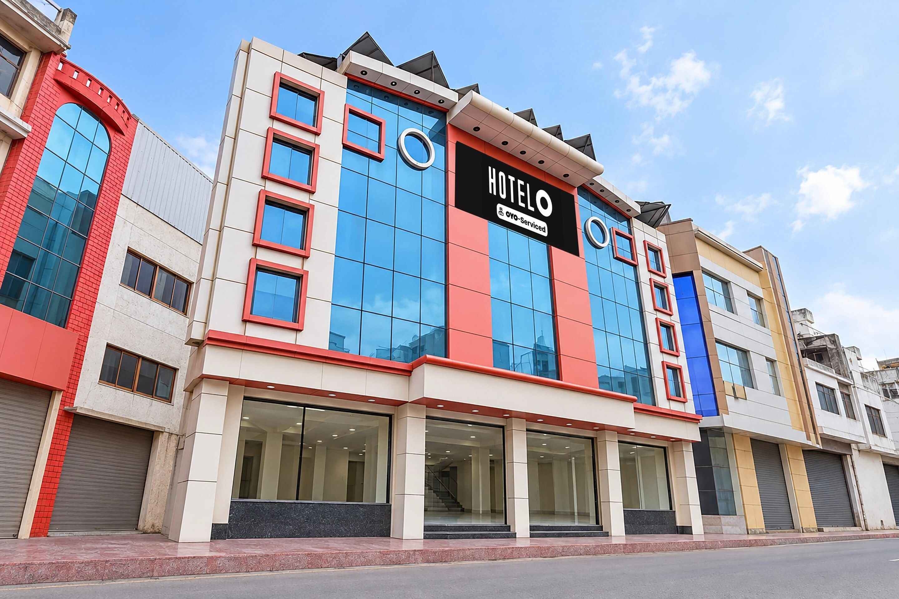 A hotel with a modern facade, large windows, and a prominent sign.