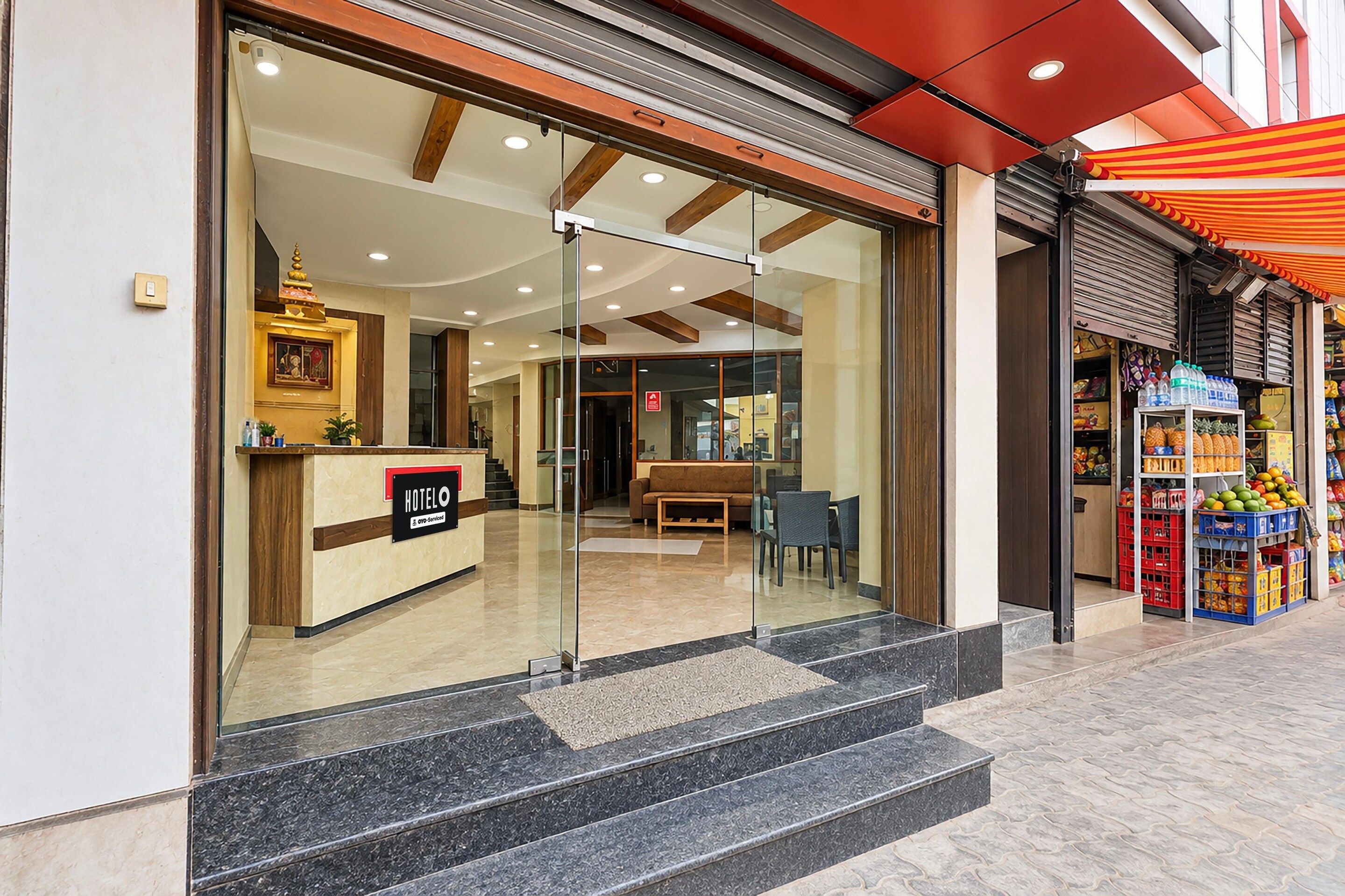 A hotel lobby with a reception desk, seating area, and a view of the street.