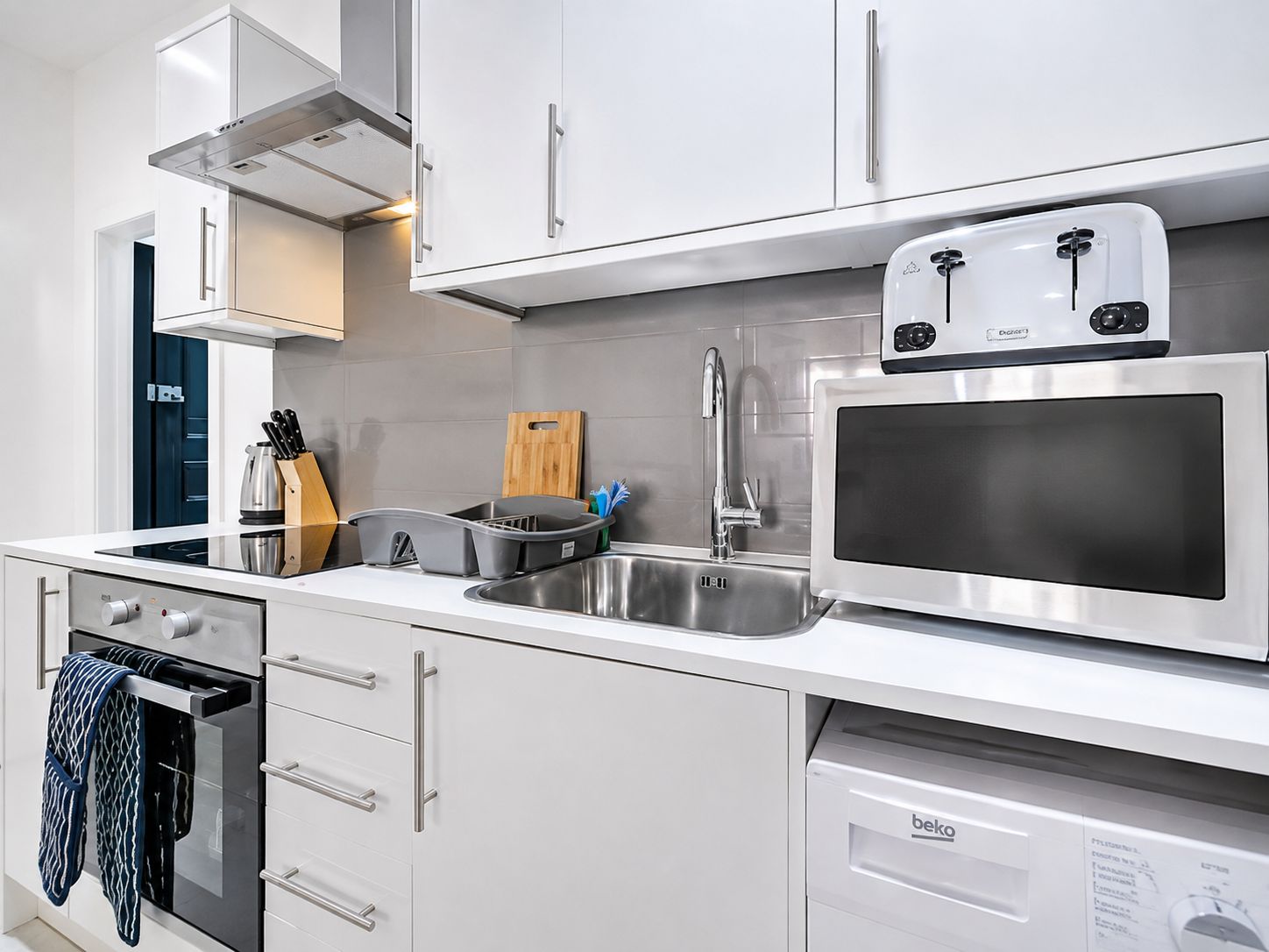 A modern kitchen with stainless steel appliances, including a microwave, toaster, and oven.