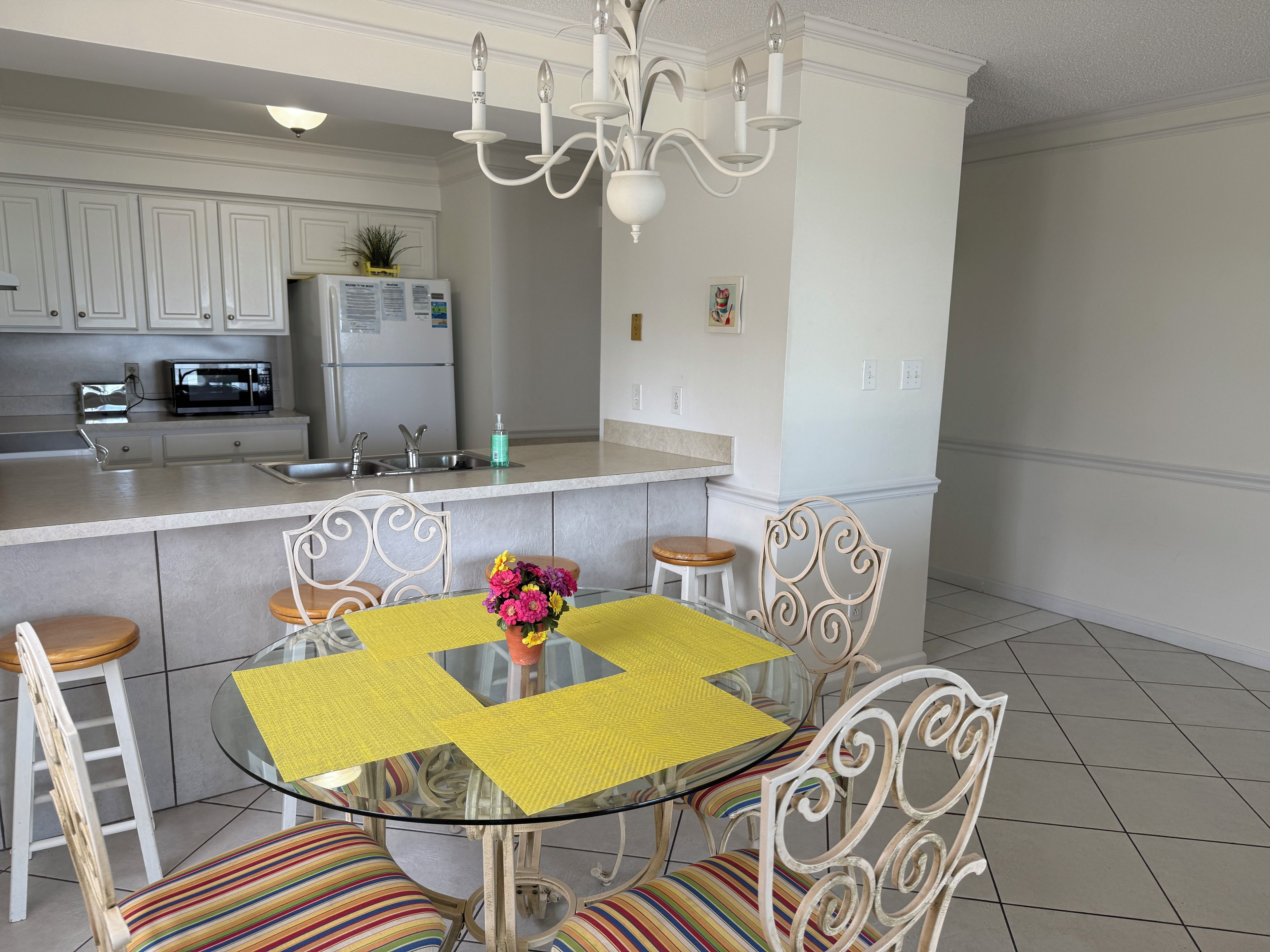 A modern kitchen with white cabinetry, a built-in microwave, and a stainless steel refrigerator.