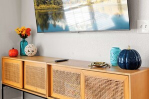 A wooden console table with a flat-screen TV mounted on the wall above. - Tampa 3BR Near Airport & MacDill | Sleeps 6 (Tampa)