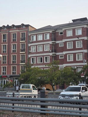 A multi-story building with a brick facade, multiple windows, and balconies.