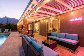 Eine Außenpatio mit Pool, Sitzgelegenheiten und einem Neon-Leuchtschild.