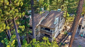 A two-story house surrounded by pine trees. - Tahoe Pines Retreat by Avantstay Pool + Sauna + Pickleball Access Bunk Room Near Lake + Skiing (Kings Beach)