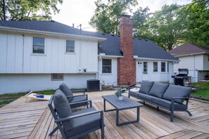 Une terrasse résidentielle aménagée avec du mobilier d’extérieur, une cheminée et un espace barbecue.