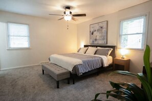 A bedroom with a bed, a ceiling fan, a nightstand, and a window. - Modern Home - Lux 5 Bdrm/3.5 Bath Sleeps 14 (Grandview)