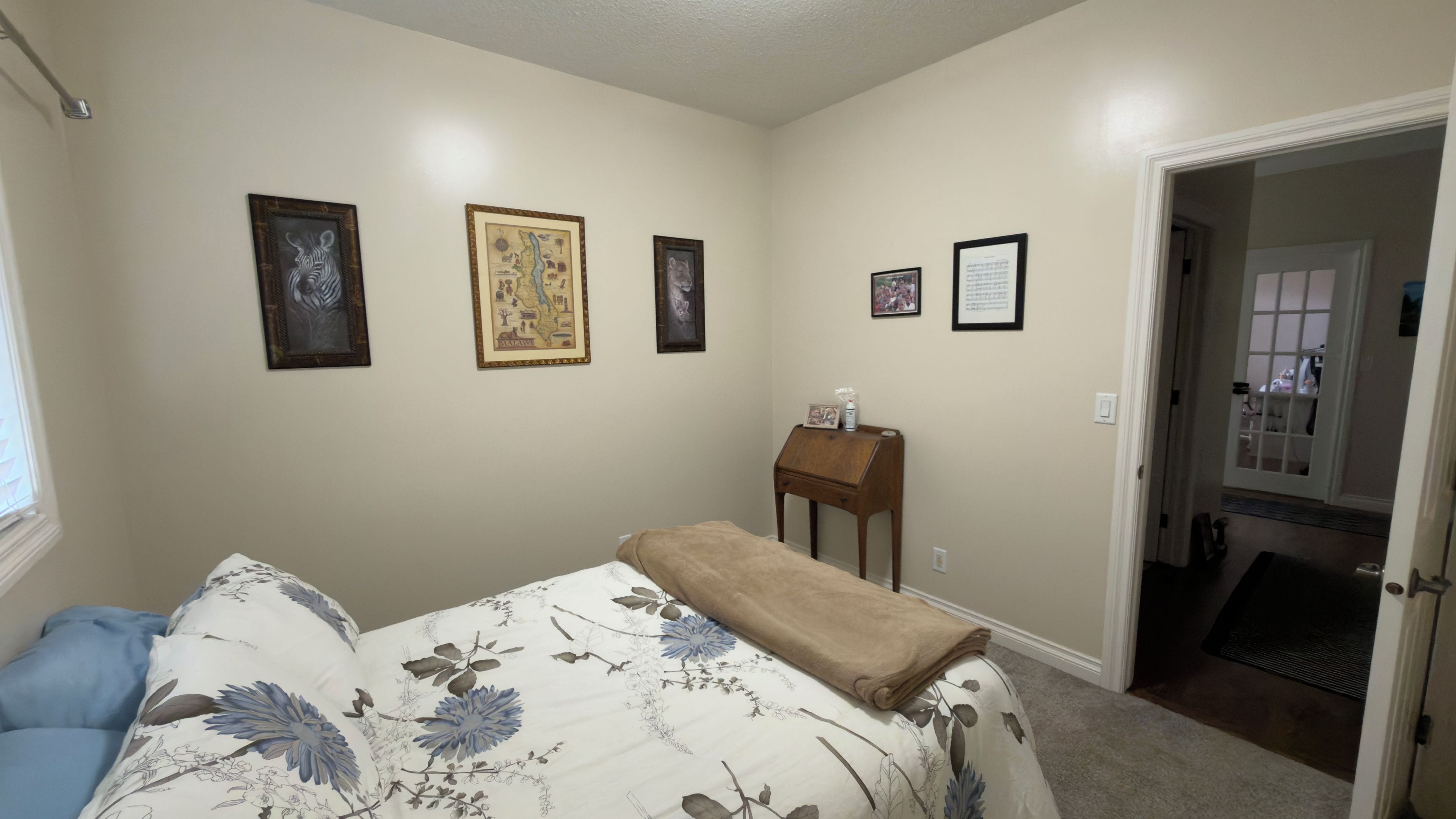 Un dormitorio con cama, mesita de noche y puerta que da a un baño.