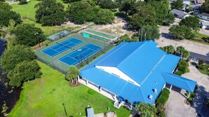 A tennis court complex with a large building featuring a blue roof. - Grace Cottage, Your Perfect Surfside Beach Getaway (Surfside Beach)