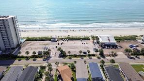 A beachside view with a parking lot, buildings, and a hotel. - Grace Cottage, Your Perfect Surfside Beach Getaway (Surfside Beach)