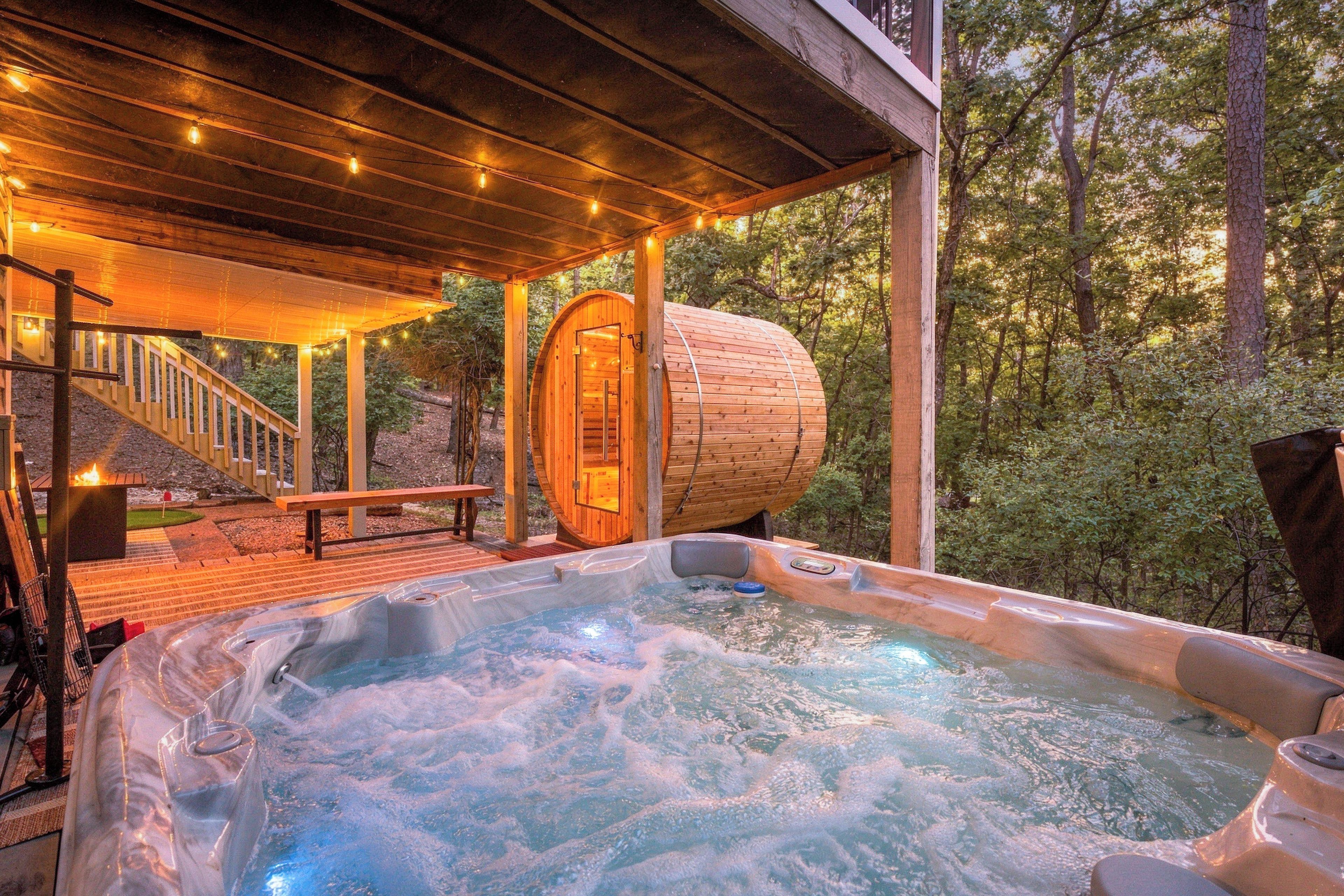 Un jacuzzi con muelle de madera y zona de estar cubierta con luces colgantes.