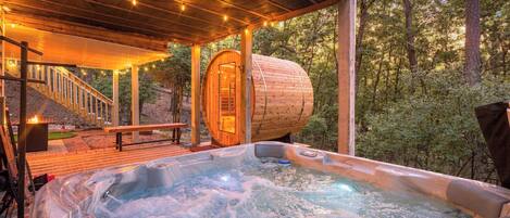 Un jacuzzi con muelle de madera y zona de estar cubierta con luces colgantes.