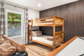 A bunk bed with a wooden frame, a checkered mattress, and a pillow with a reindeer design. - Designer 6BR in Massanutten with Hot Tub, Sauna (McGaheysville)