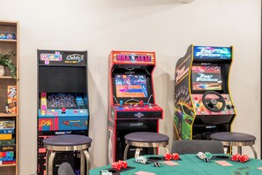 Three arcade machines, a table with poker chips, and a plant. - Designer 6BR in Massanutten with Hot Tub, Sauna (McGaheysville)