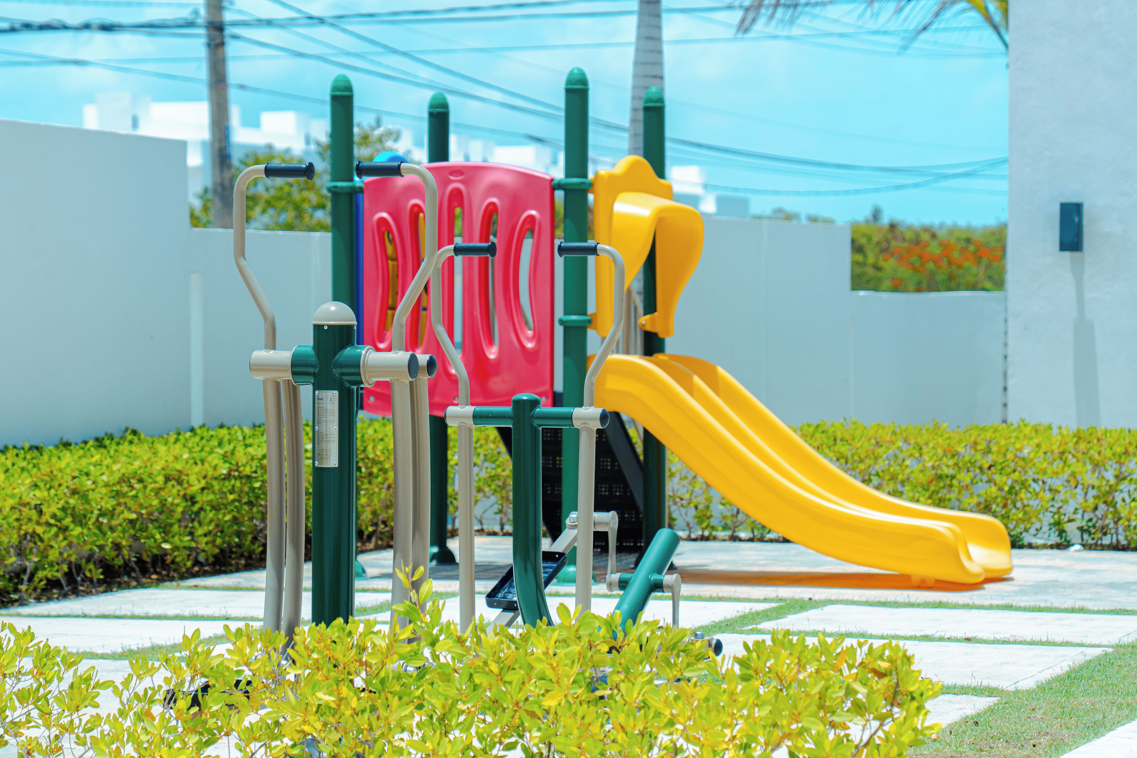 Uma área de recreação infantil com um escorrega amarelo e estruturas para escalar.