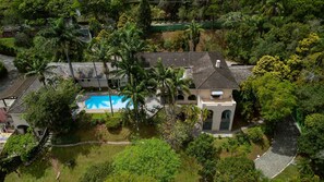 A residential property with a swimming pool, multiple buildings, and lush greenery. - 5 QTS Fut Tenis Sauna Boate 30min SP (Carapicuíba)