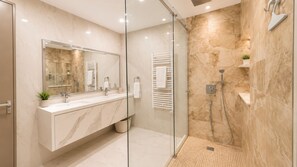 A modern bathroom with a glass-enclosed shower, a marble vanity, and a large mirror. - Trident Luxury Beach Apt by TrulyCyprus (Paralimni)