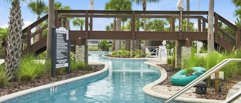 A swimming pool with a bridge, palm trees, and a sign indicating no diving.