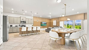 Una cocina moderna con comedor, ventanas amplias y vistas al exterior.