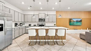 A modern kitchen with a central island, stainless steel appliances, and pendant lighting. - 10BR Luxury Villa, Pool & Hot Tub, Windsor Cay (Clermont)