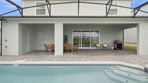 A covered patio area with a pool, outdoor seating, and a barbecue grill. - 10BR Luxury Villa, Pool & Hot Tub, Windsor Cay (Clermont)