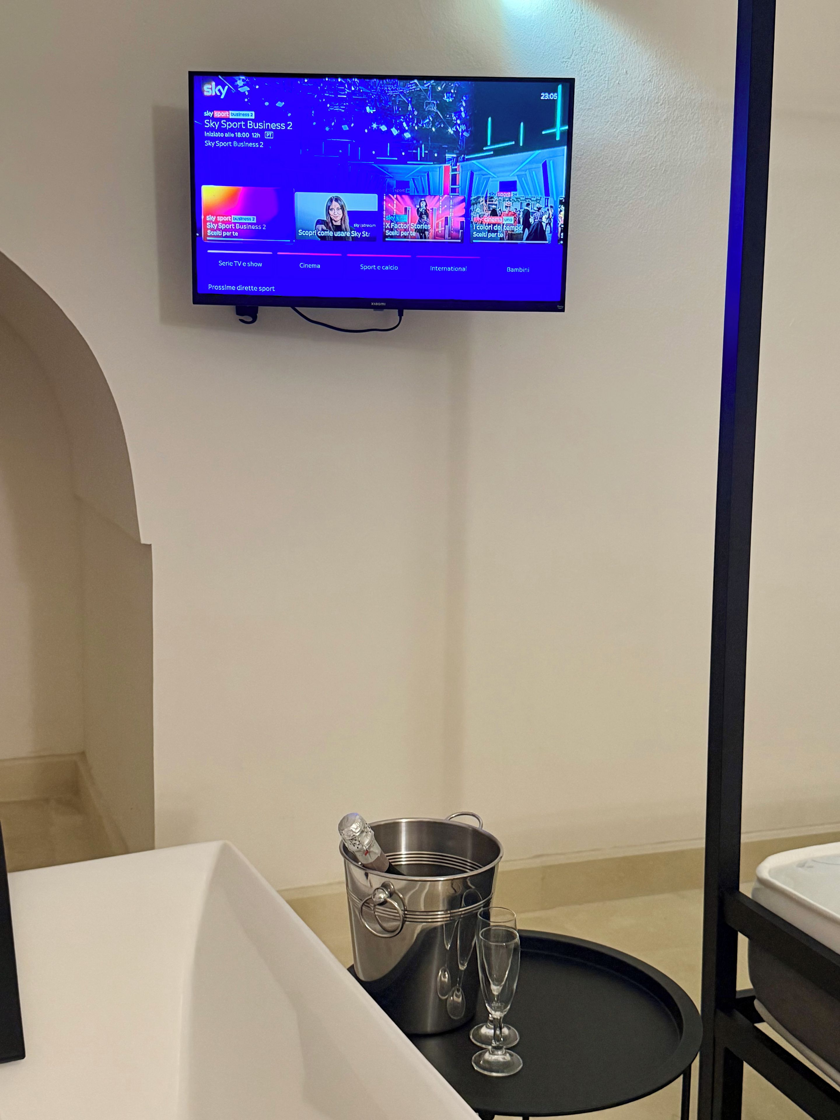 A television mounted on a wall displaying Sky Sport Business 2.